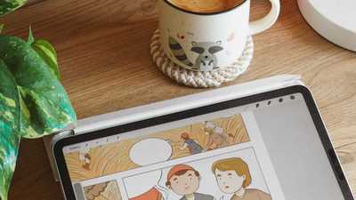 Espaço de trabalho aconchegante com tablet exibindo arte digital, café e planta