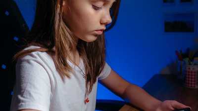 Jovem lendo em tablet numa mesa, ambiente aconchegante de estudo