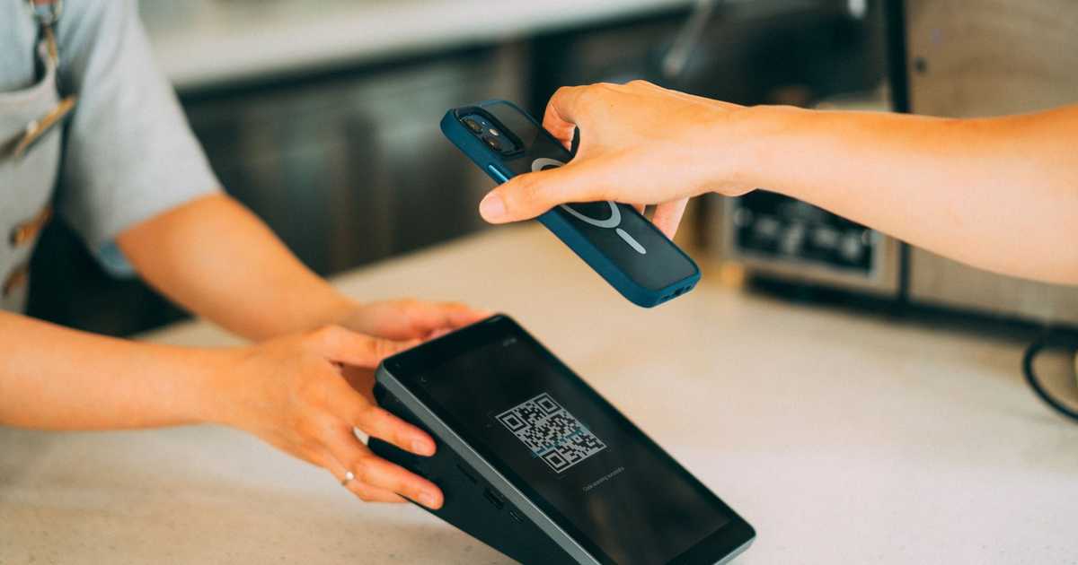 Pagamento por aproximação com smartphone e leitor de QR Code em ambiente de varejo