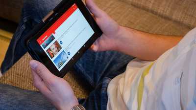 Homem segurando tablet assistindo vídeo em aplicativo de streaming