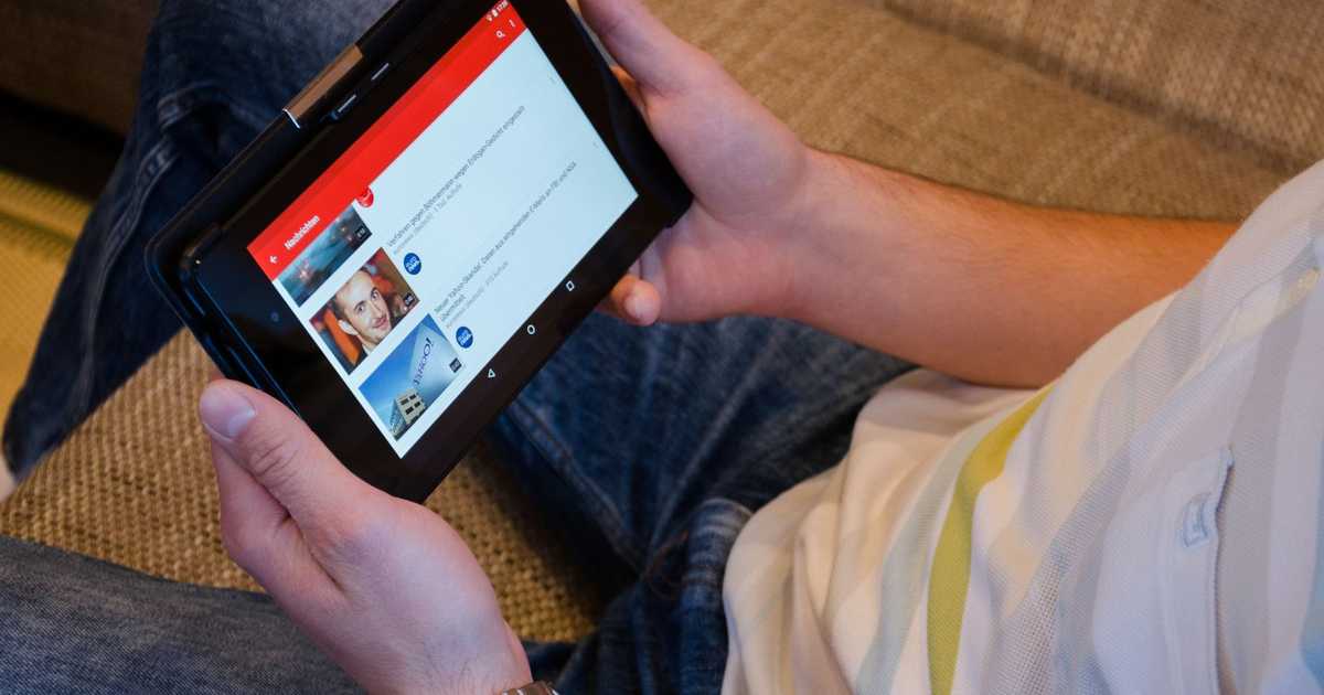 Homem segurando tablet assistindo vídeo em aplicativo de streaming